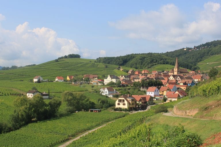 Randonnée en Alsace - vue d'un village dans une vallée ensoleillée - crédit la Pélerine